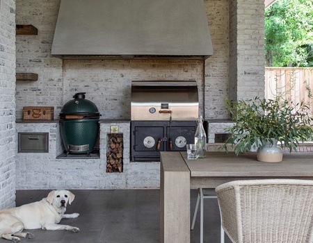 Custom outdoor kitchen with built in Big Green Egg and wood burning grill. White Washed brick and custom vent hood make a beautiful place for friends and family to gather in Houston, TX