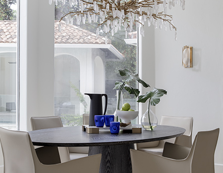 Breakfast room with modern custom table and four leather chairs and large glass chandelier in Houston, TX