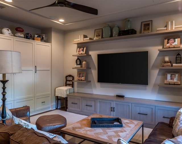 High end media room with custom built in storage and floating shelves in Houston, TX.